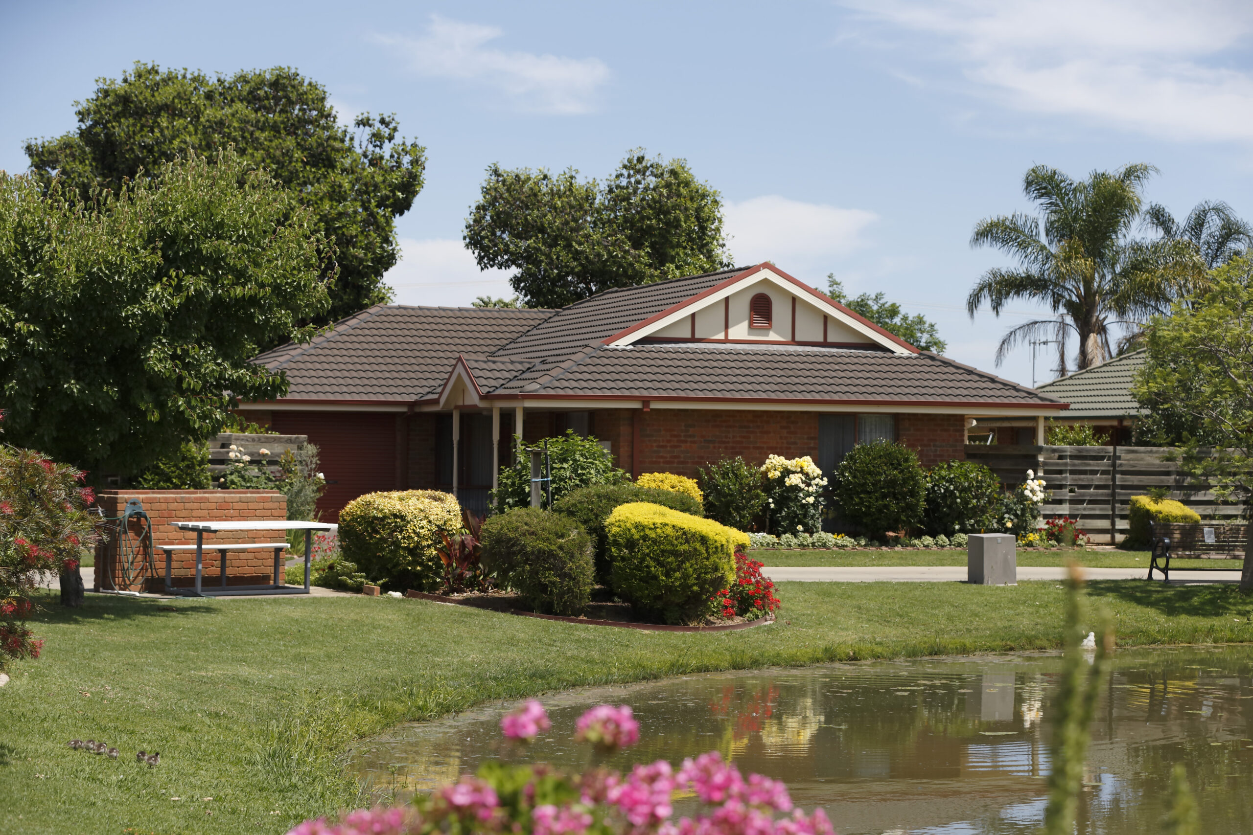 Exterior of Shepparton Independent Living Unit with manicured gardens and lake